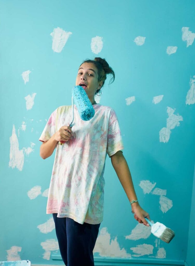 happy-woman-painting-interior-wall-with-paint-roller-in-new-house-e1678323493469